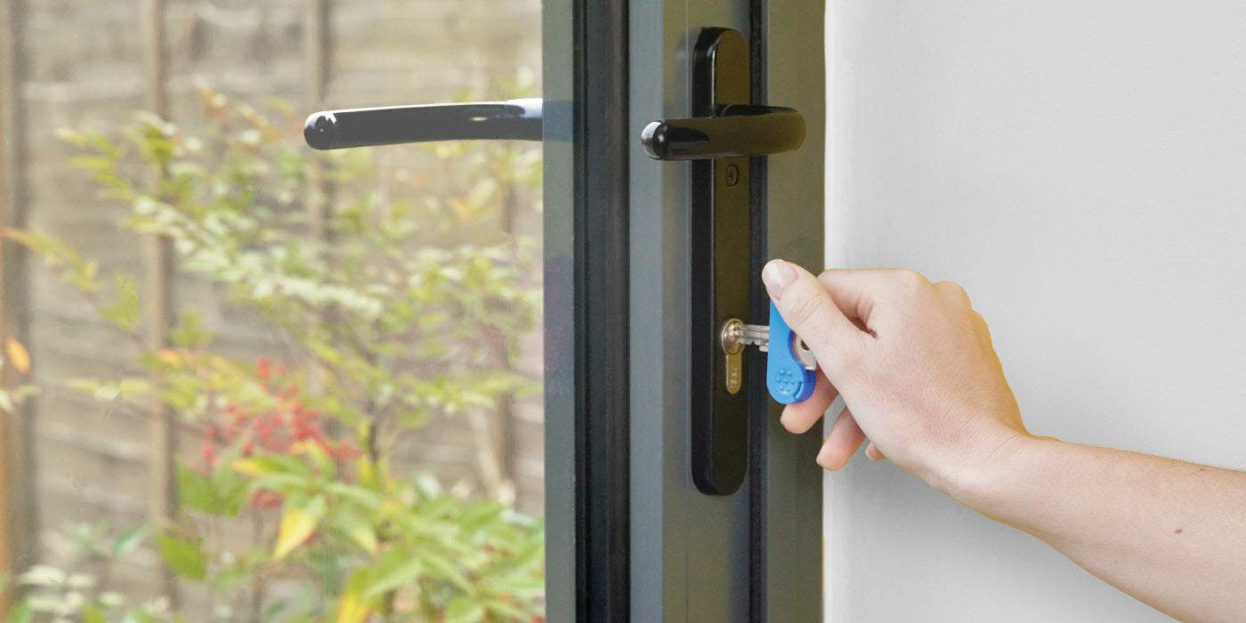 Header image of a blue keywing key turner used in a lock on an internal door with an arthritis hand.