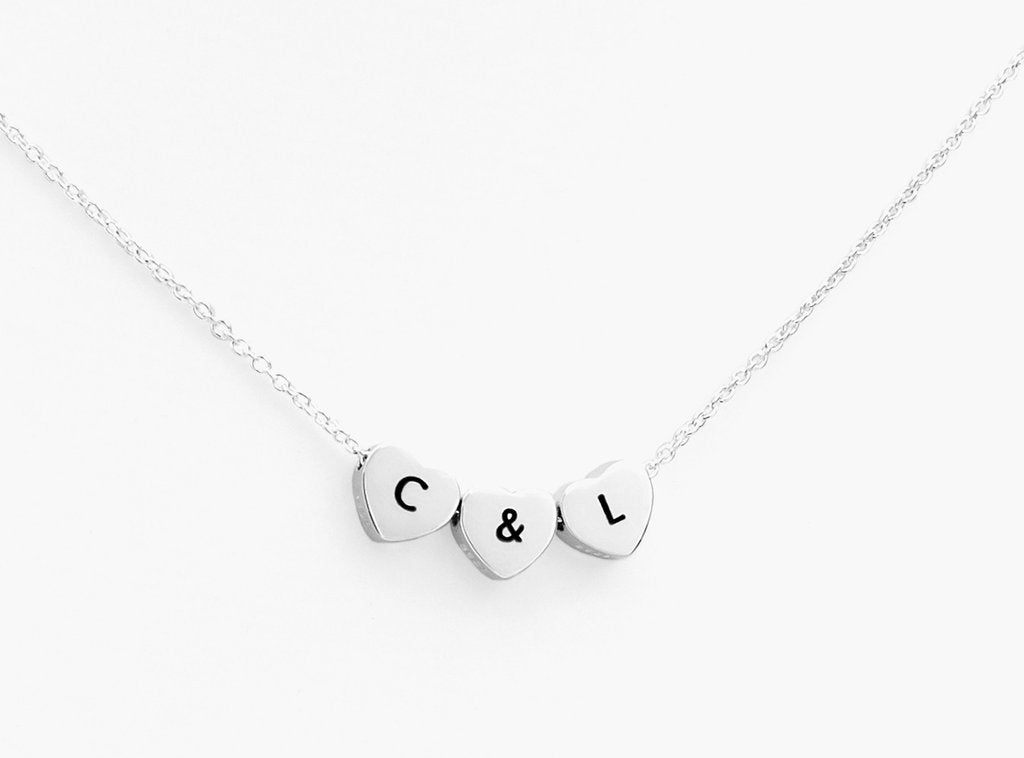 Silver trio hearts on a chain with symbols or intials