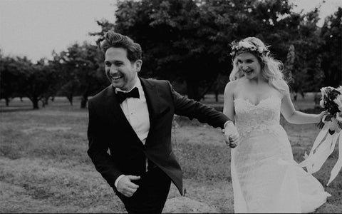 Andrew and Megan holding hands running together on their wedding day.