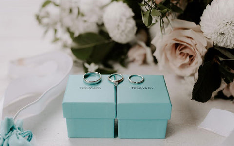 Megan and Andrews engagement ring and wedding bands on top of Tiffany's boxes.