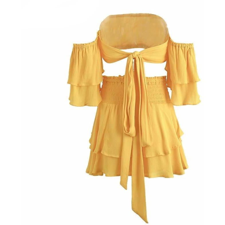 The Amani Romper is a unique design featuring a crop style bell sleeved top, sash waist tie, and an asymmetrical tiered ruffle bottom. Three colors available: yellow, red, and black.