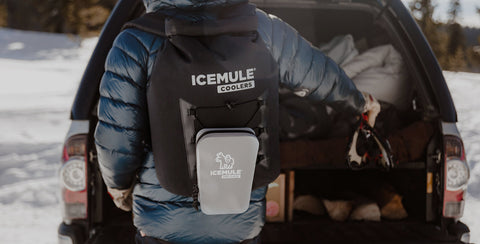 A person carries their IceMule cooler as they prep for an adventure.
