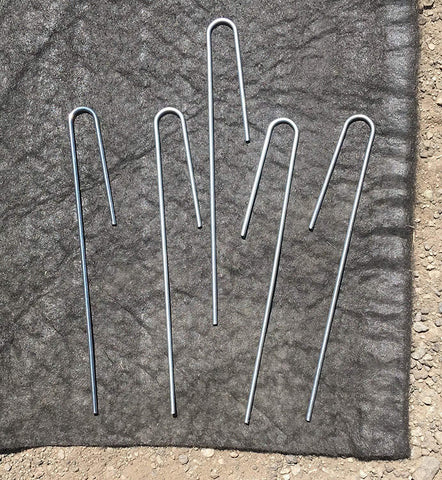 5-inch Drip Irrigation Tubing Hold Down Stakes lying on a cloth on the ground