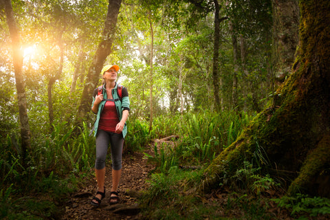 A woman hikes during the summer wearing the best rain jacket for hiking.
