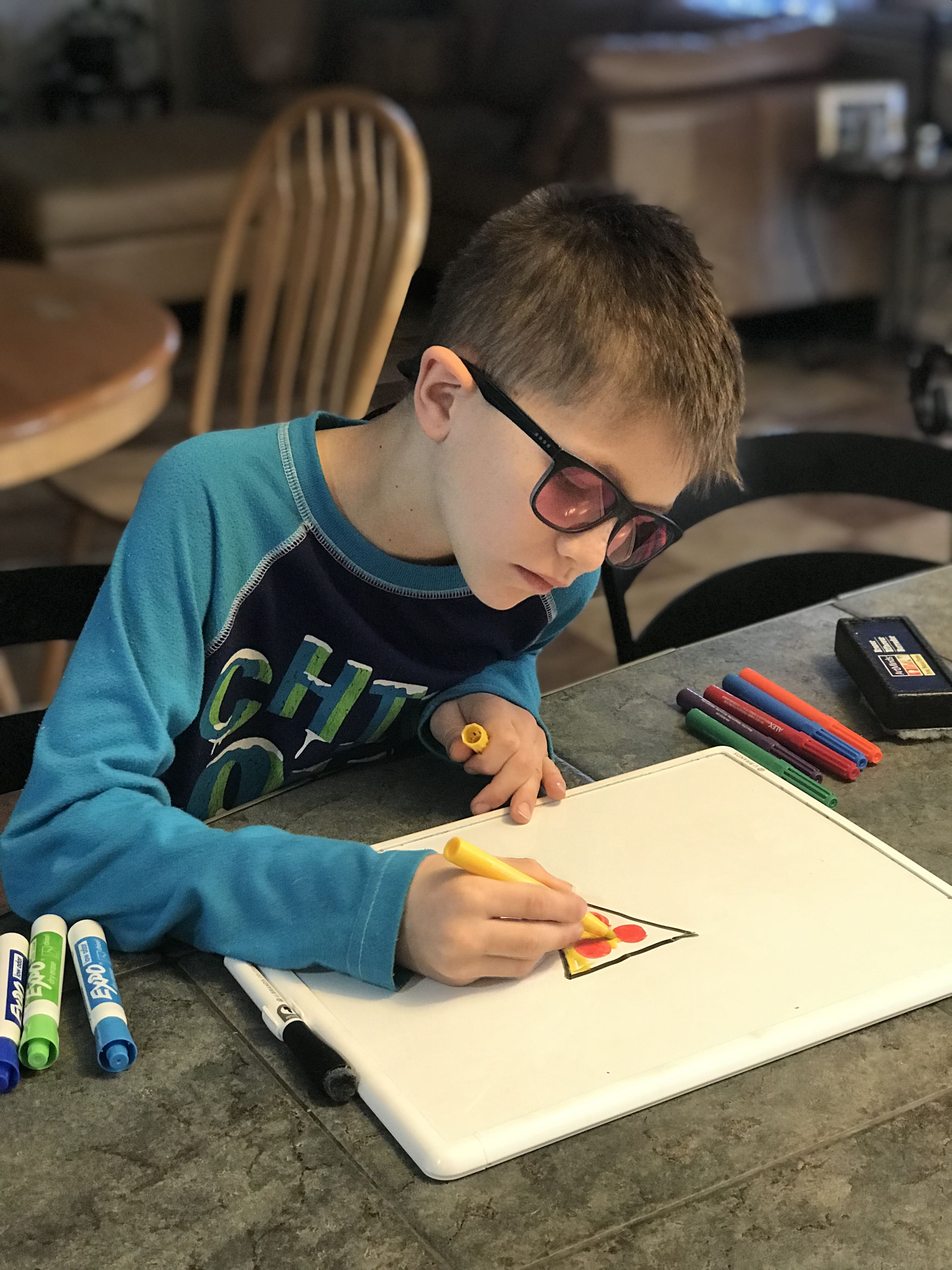 young color blind boy drawing with glasses
