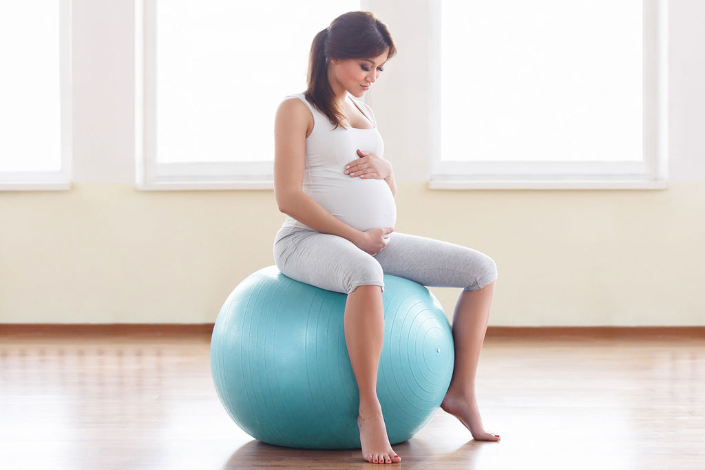 Pregnant woman sat on birthing ball with good posture
