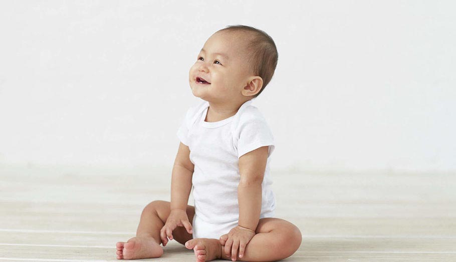 smiling baby wearing white bodysuit