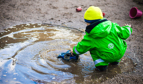 little boy at a puddle