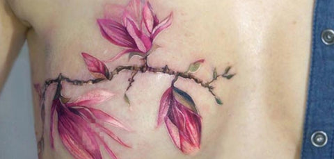 Bright watercolor designed breast tattoo