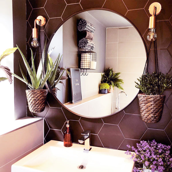 Dark bathroom interior with geometric tiles and brass wall lights