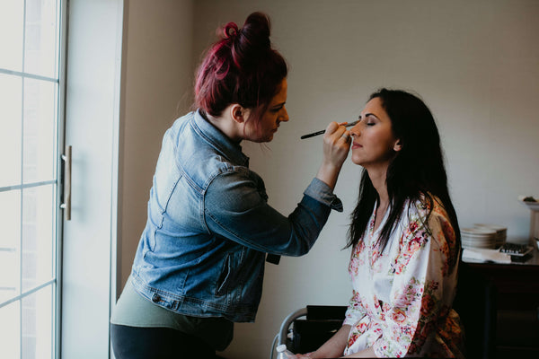 makeup artist doing bride's makeup | Wedding Planning Checklist