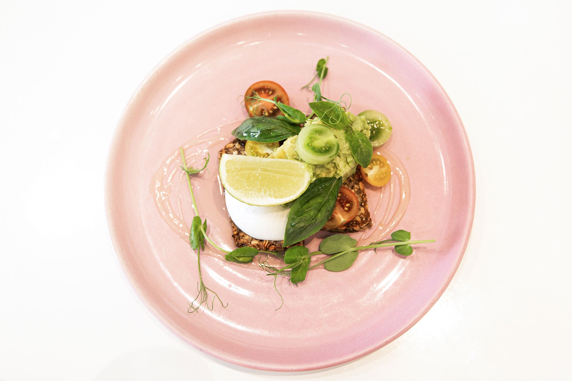 Pink Plate with Seed Loaf, Avocado, Tomatoes at Catroux Cafe Auckland