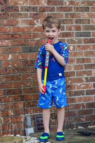 Boy with squirt fun wearing Beau and Belle Littles Shark Rashguard