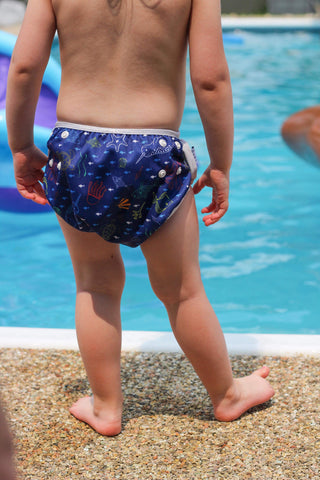 Little kid standing by the pool in the Beau and Belle Littles Sea Friends swim diaper. 