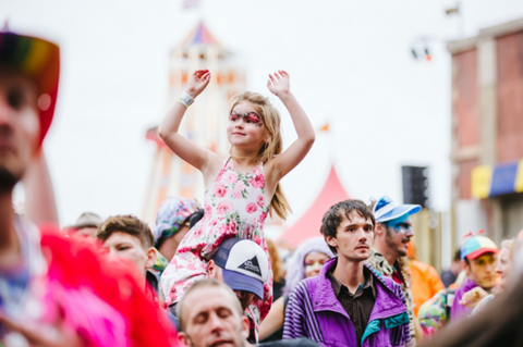 Child on parents shoulders at Boomtown festival