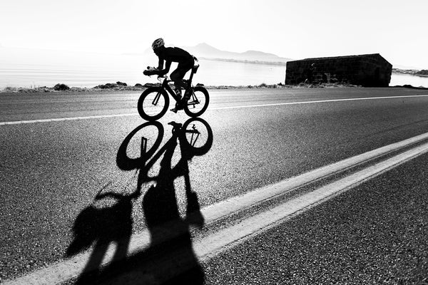 back and white image of cyclist training on-road