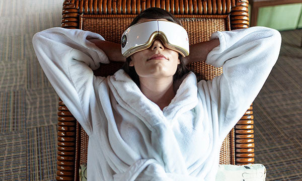 Woman wearing the Eye Massager in a chair, view overhead