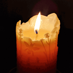beeswax candle burning with lavender and bee design