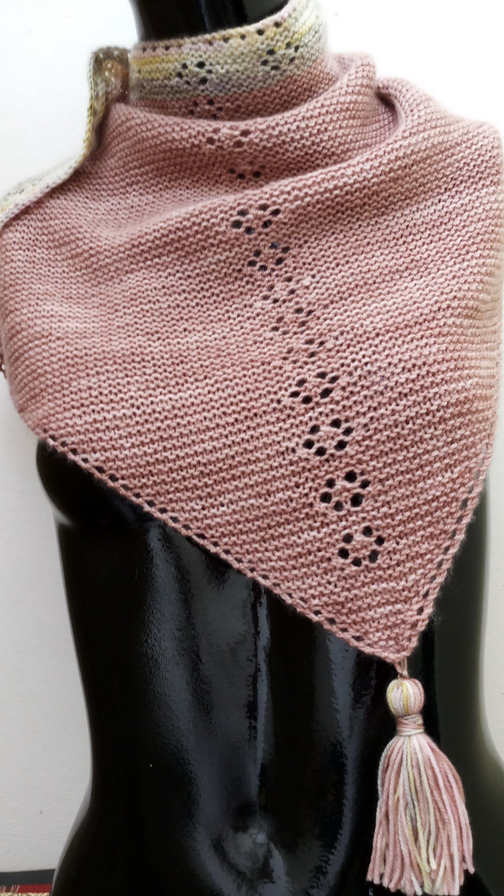 A pink shawl with paw print lace details down the spine