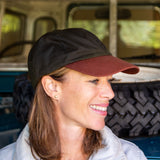 olive green wax sports cap with brown peak on woman