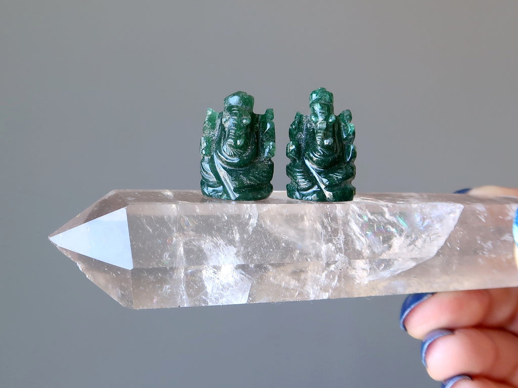 a pair of dark green ganesh elephant god aventurine figurines on a quartz wand.
