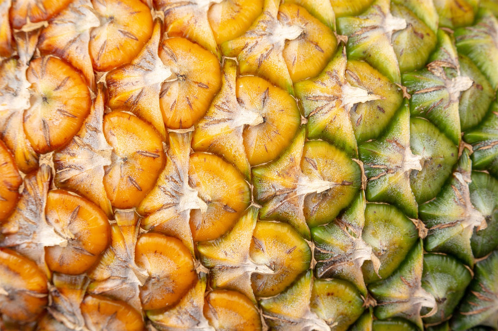 close up of yellow and green pineapple skin
