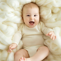 baby wearing cream merino bodysuit