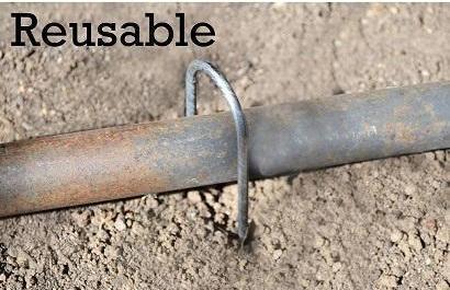 Reusable 6-inch Round Top Galvanized Landscape Staples used to hold down a pipe