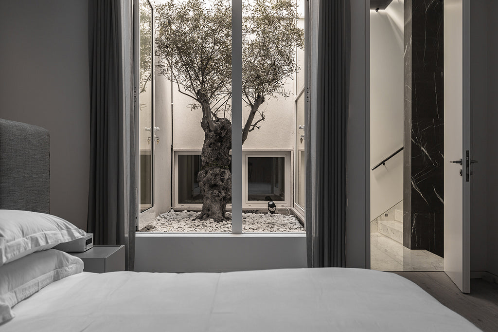 bedroom in grey tones with view to the courtyard
